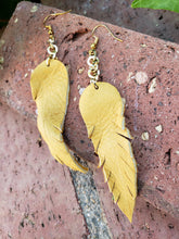 Mustard dangling feather earrings